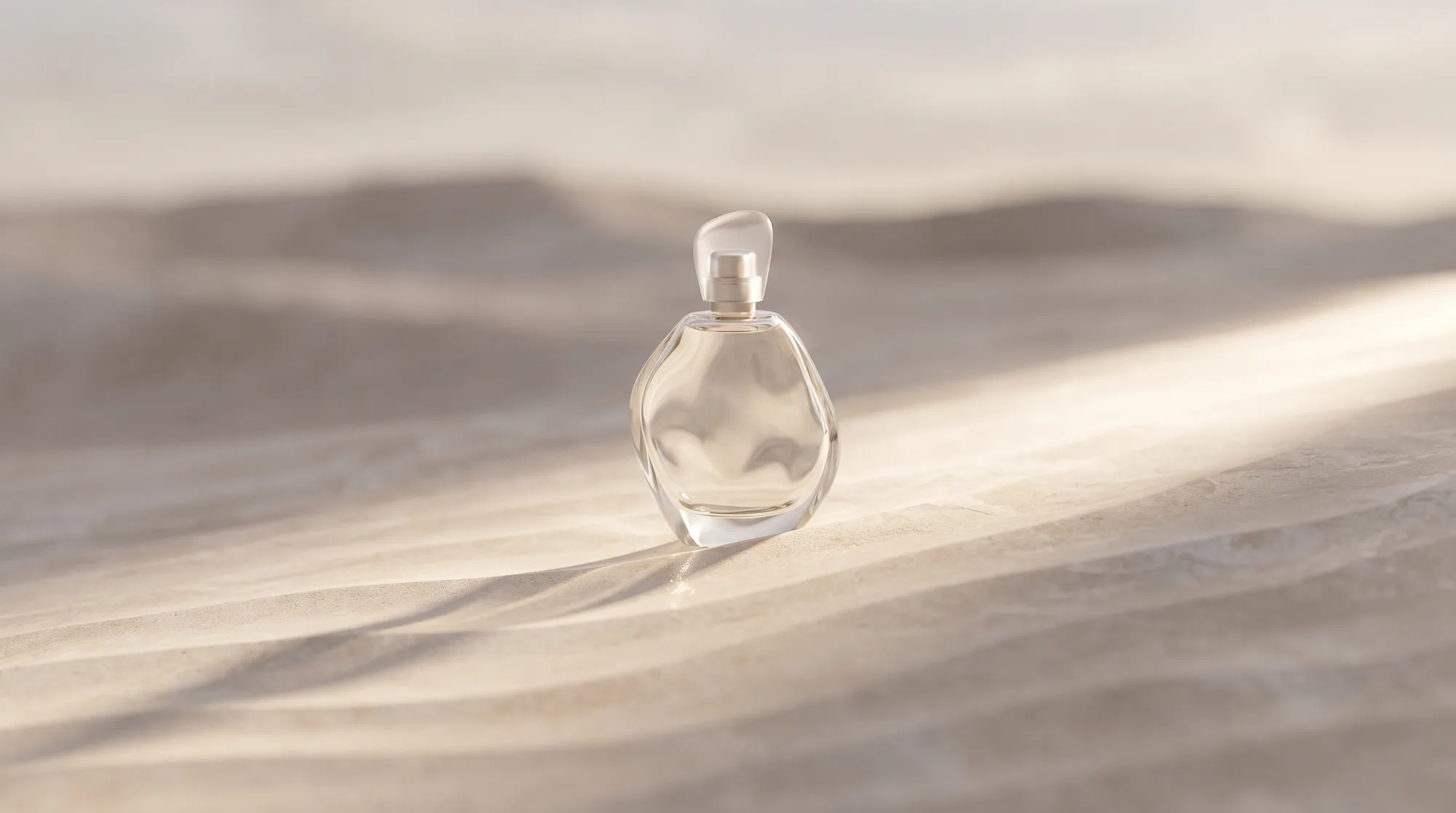 Sculptural glass perfume bottle on rippled stone, cinematic still