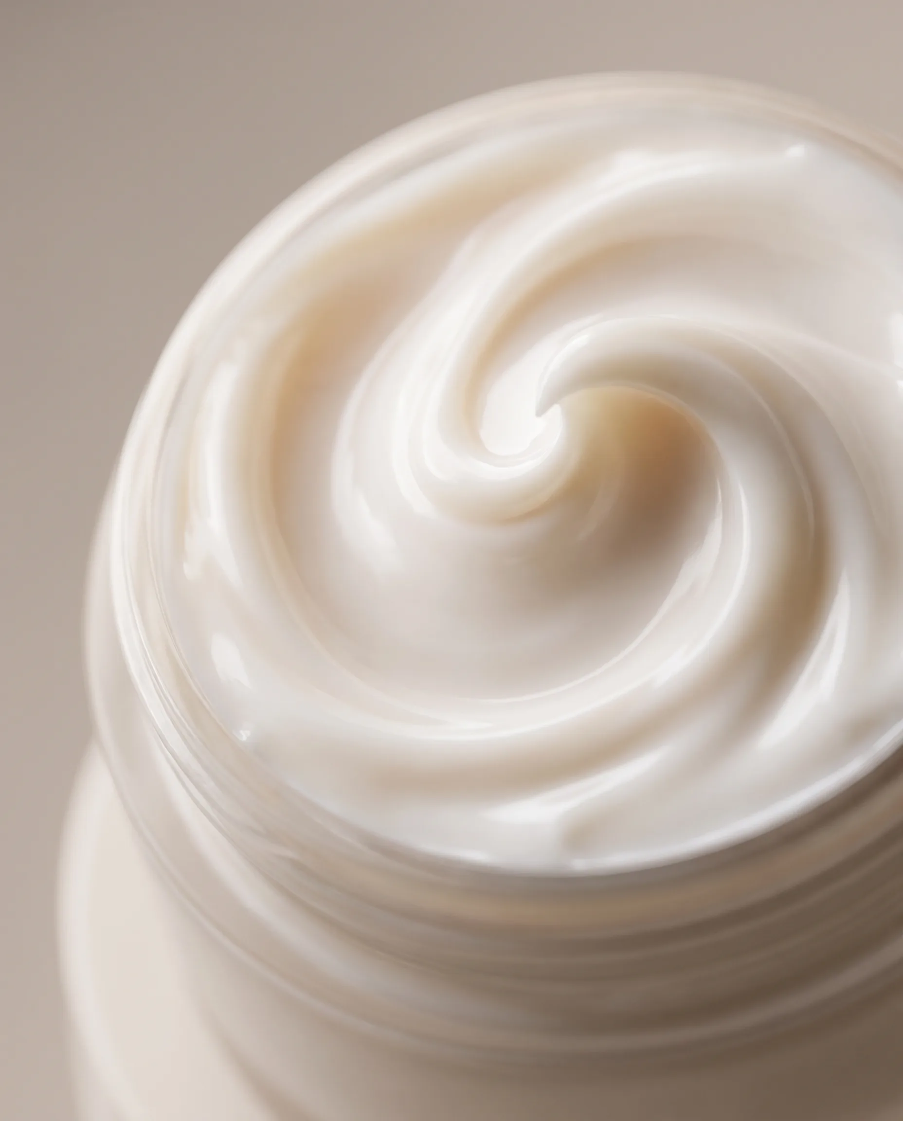 Macro render of a sculpted skincare cream texture in warm ivory tones