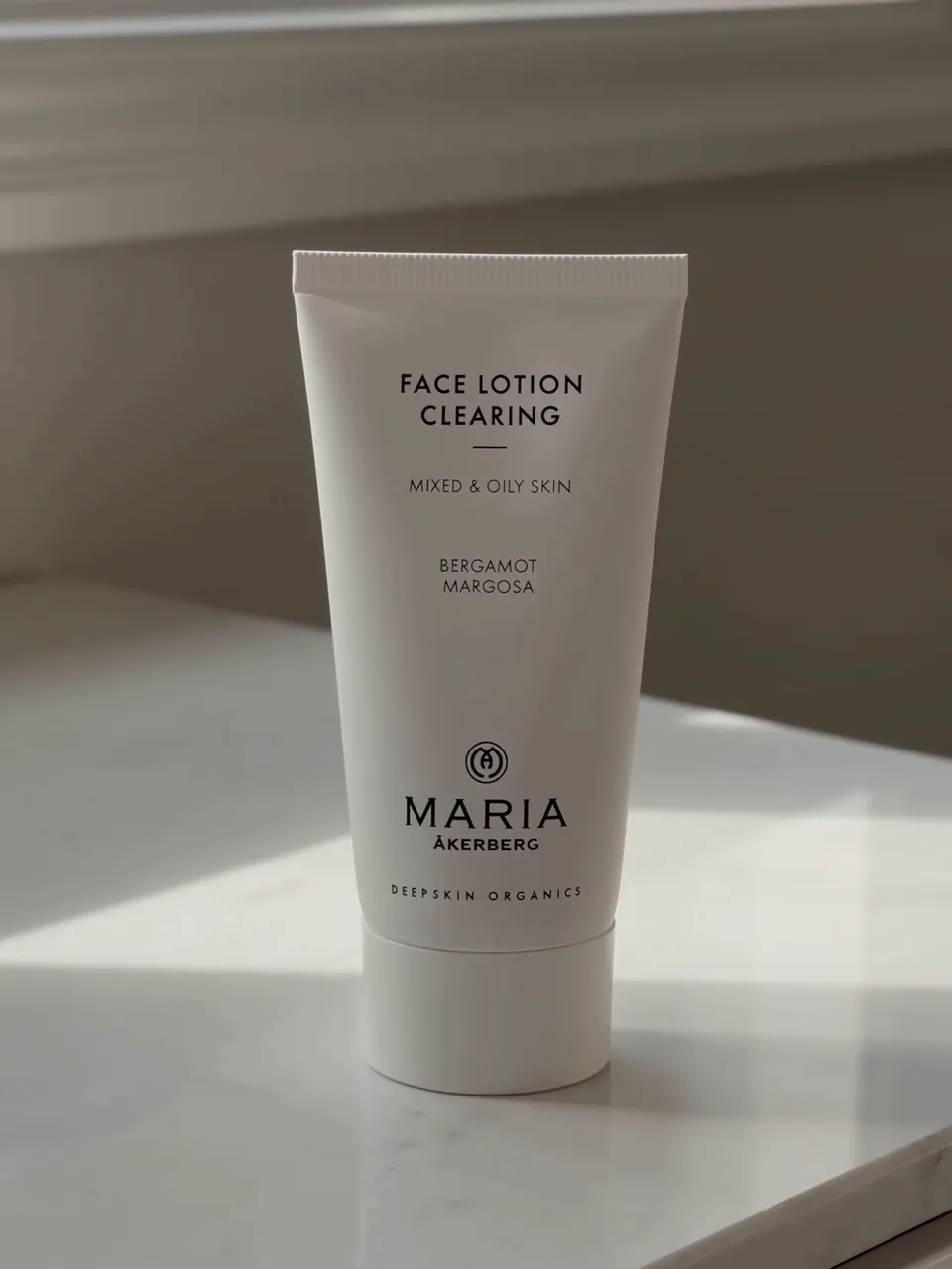 Face Lotion Clearing tube standing on a marble counter in window light, frame from the AI UGC sample
